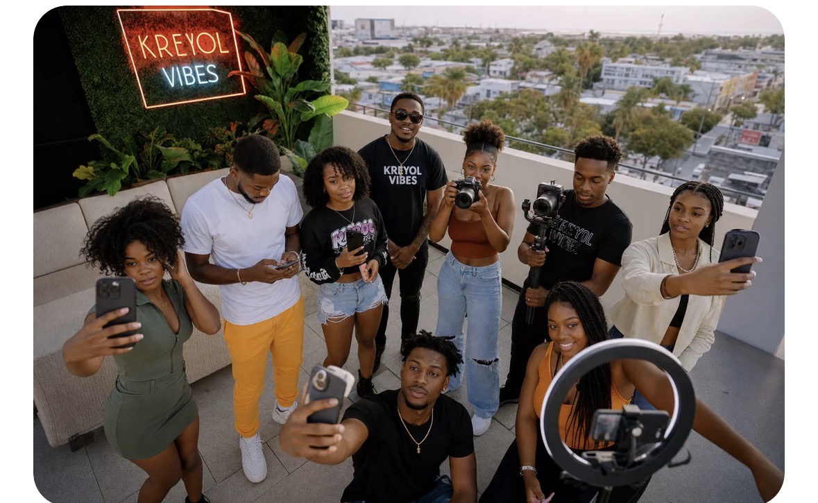 A group of Haitian content creators filming together on a rooftop under a KREYOL VIBES neon sign